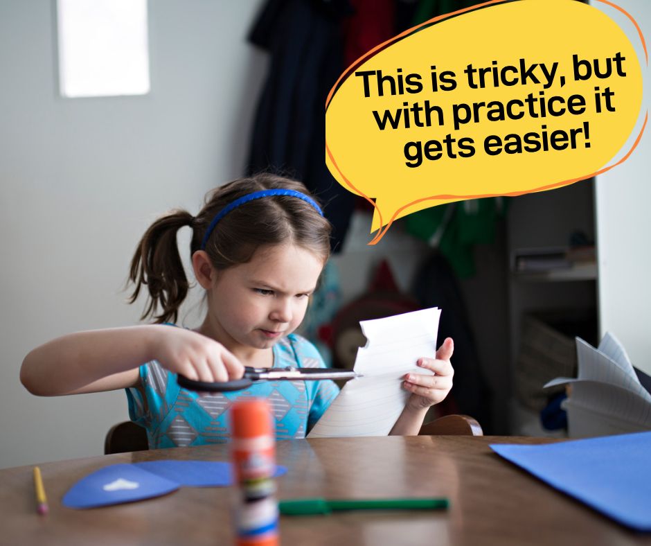 An image of a young girl concentrating on cutting a piece of paper with scissors, with a speech bubble above her head that says "this is a bit tricky, but with practice it gets easier".